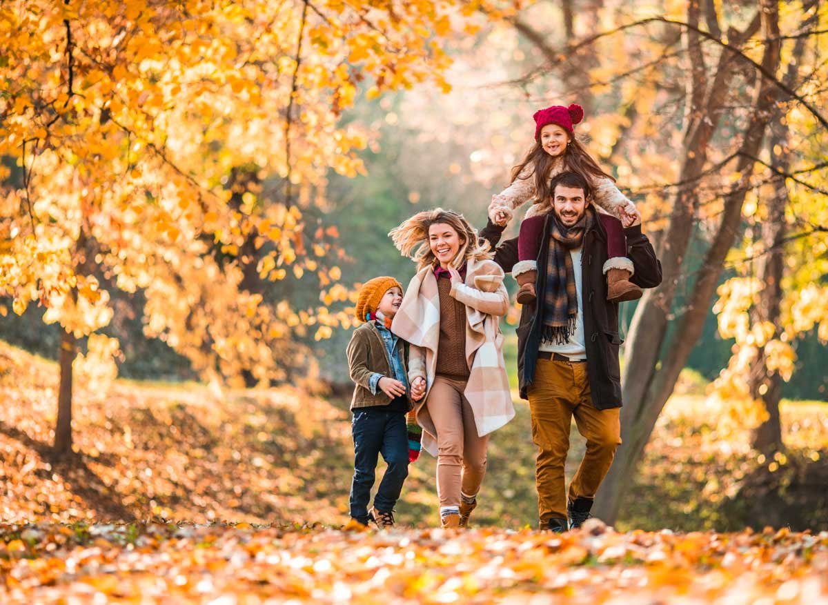 Familie som går tur i skogen på høsten